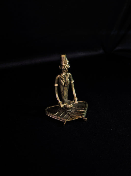 Dhokra - Tribal Lady musician sitting and playing Drum